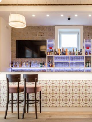 Elegant bar with wooden chairs and stone walls.