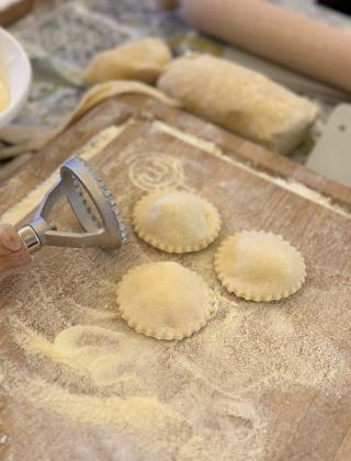 Preparazione di ravioli fatti in casa su un tagliere infarinato.